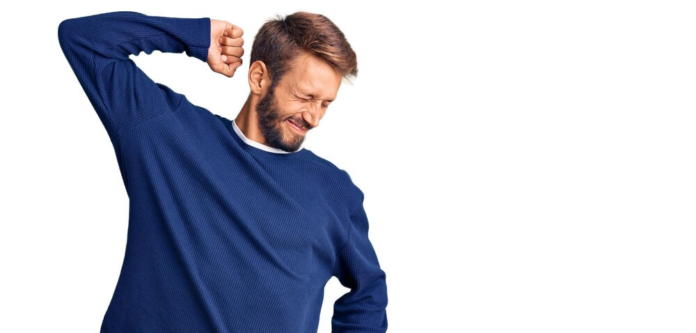Handsome blond man with beard wearing casual sweater stretching back tired and relaxed sleepy and yawning for early morning